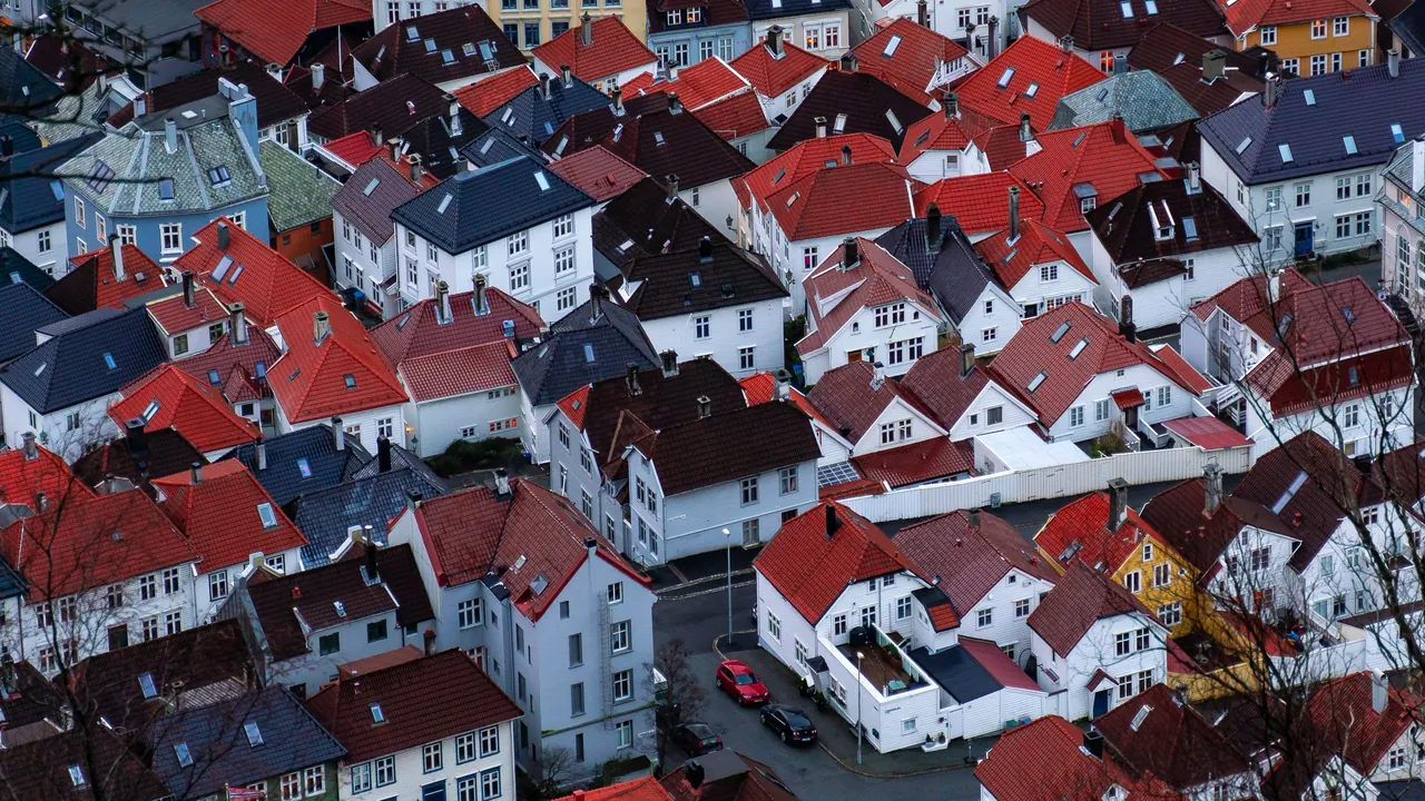 Rote Ziegeldächer dicht bebauter Wohnhäuser von oben